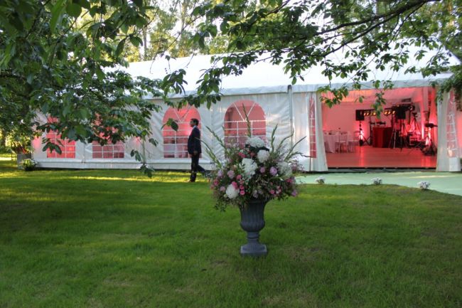 Décoration florale devant la tente de 150m² avec plancher.